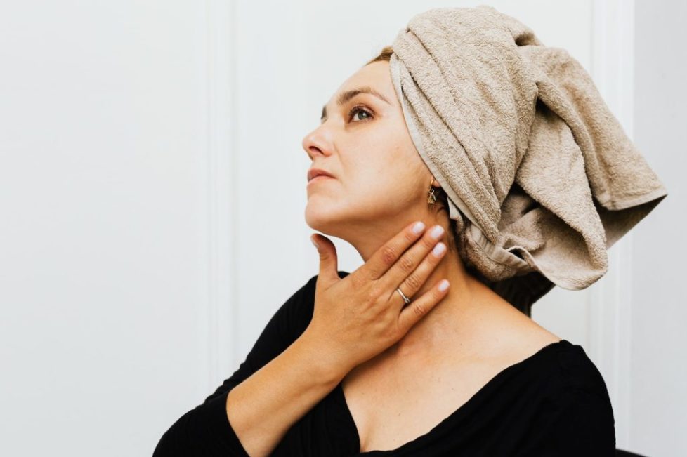 a woman in black long sleeves with bath towel on her head