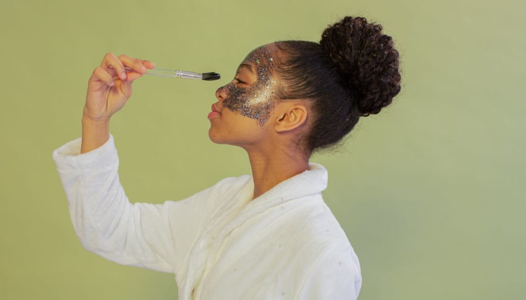 black woman applying facial mask with brush