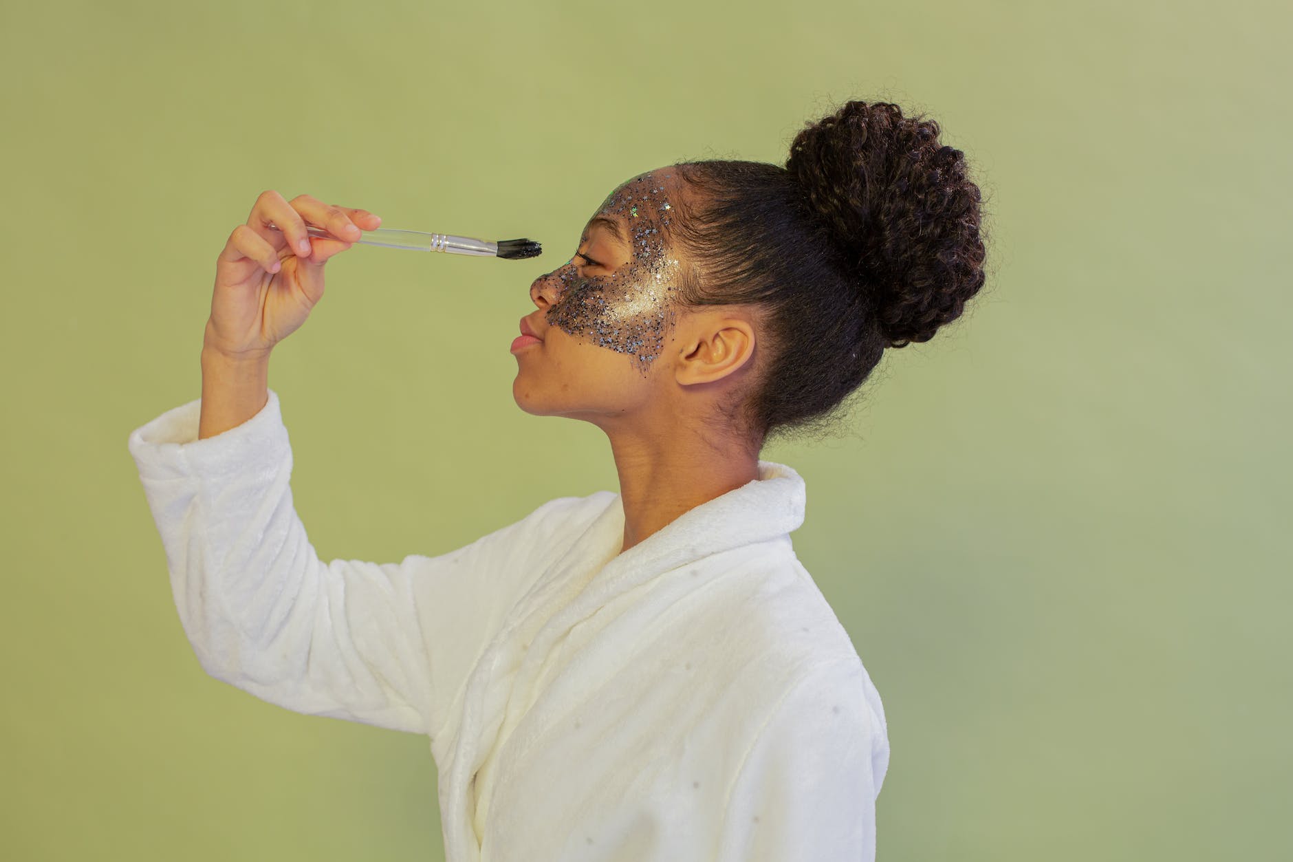 zwarte vrouw die gezichtsmasker met borstel toepast